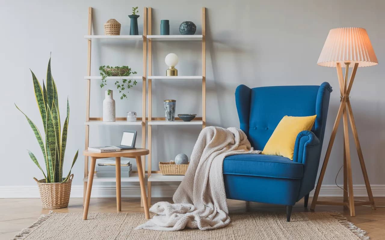 Living room corner with blue armchair, yellow cushions, floor lamp, soft throw, cozy and stylish Pinterest-ready interior