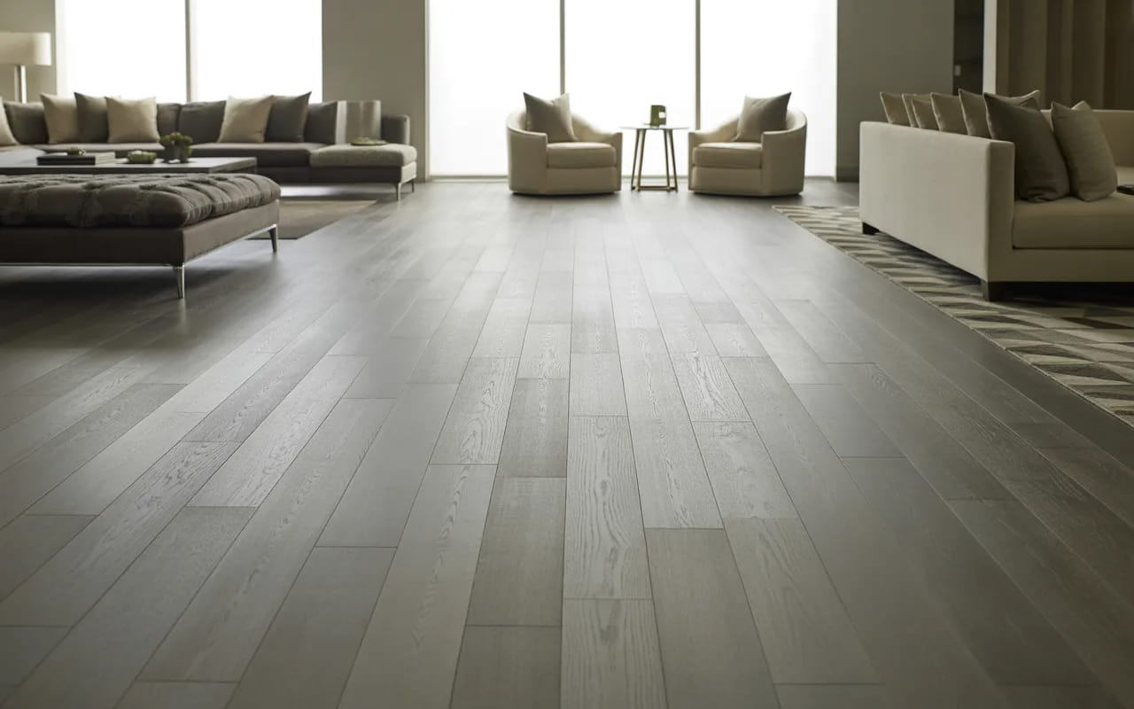 Spacious living room with grey flooring and multiple seating zones.