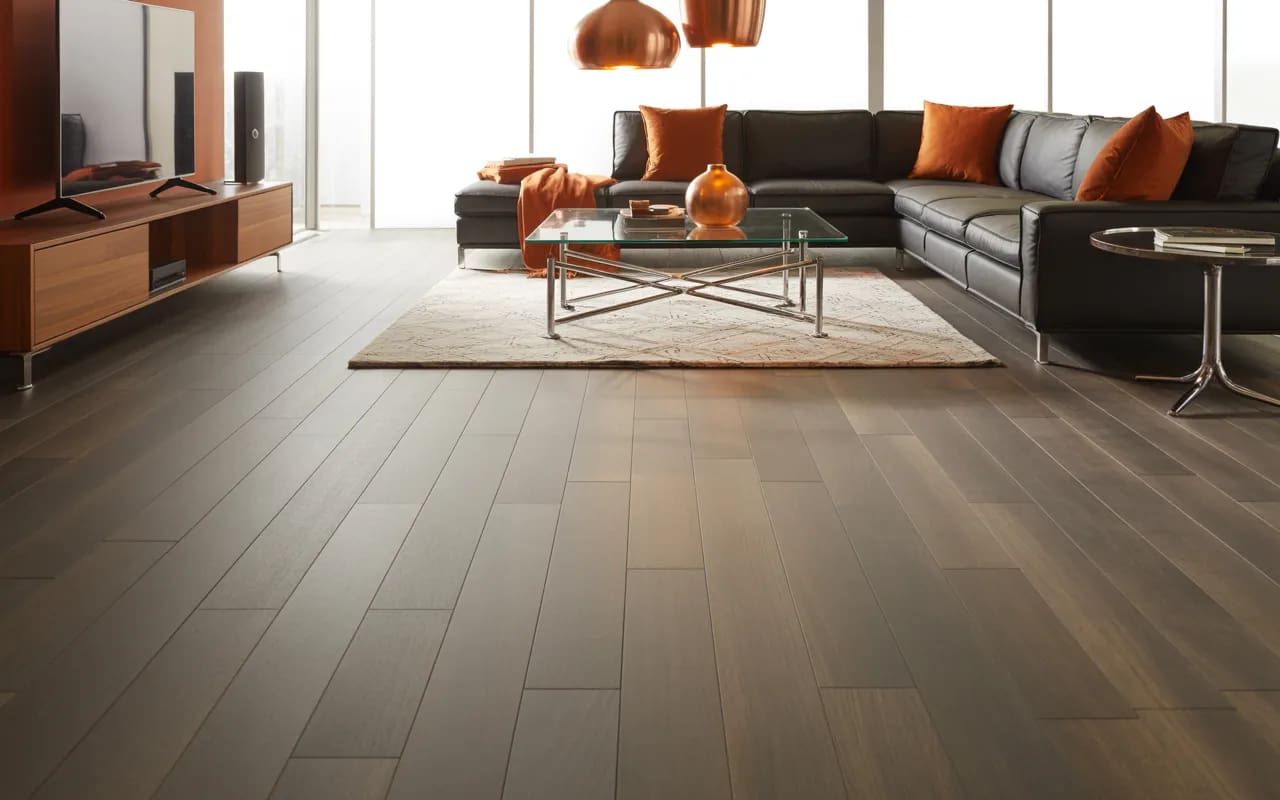 Living room with mid-grey flooring, contemporary furniture, and warm accent pieces.