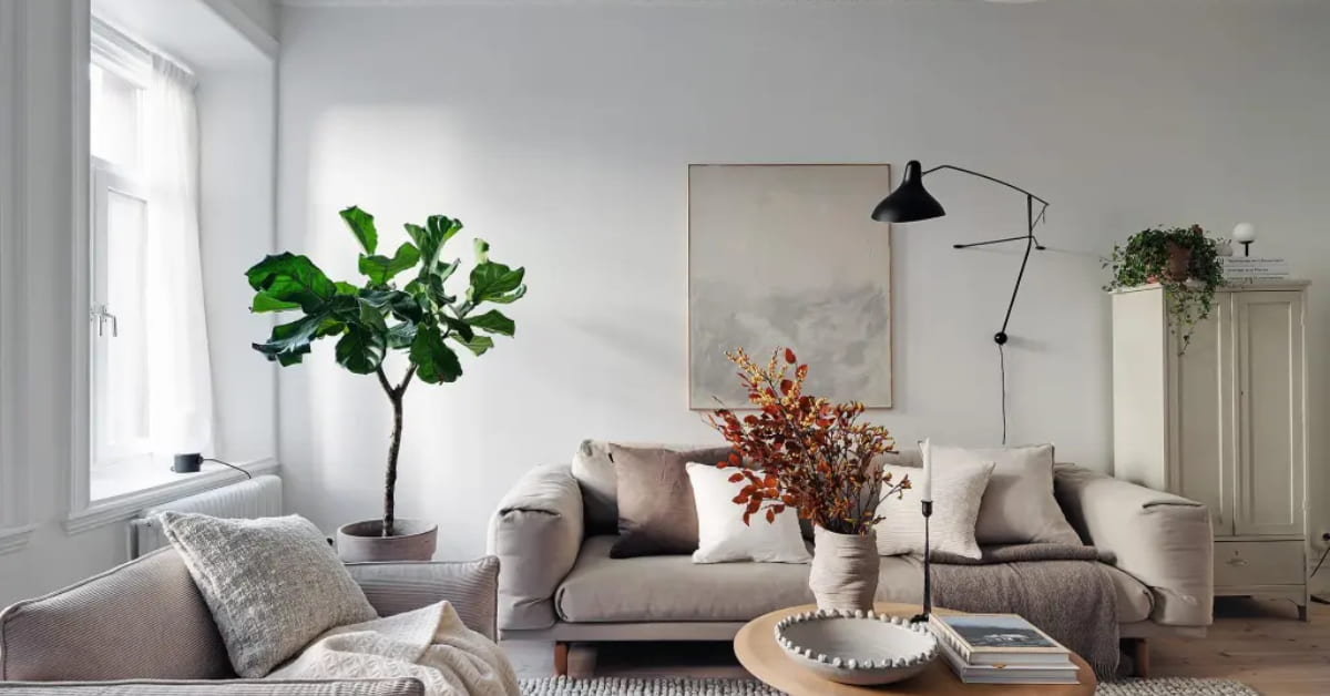 “Small living room with concrete floor, wooden coffee table, dark beige sofa, layered cushions, modern stylish décor