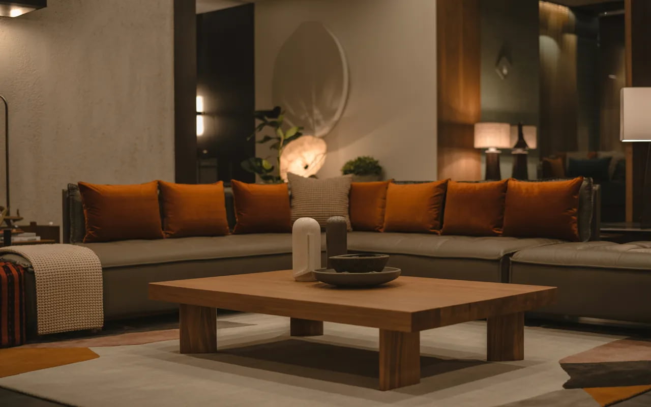 Living room with dark beige sofa, burnt orange cushions, wooden coffee table, cozy warm décor, modern stylish interior”