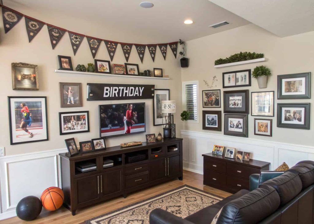 Personalized birthday living room décor with framed photos, hobby-themed decorations, name banner, stylish masculine setup