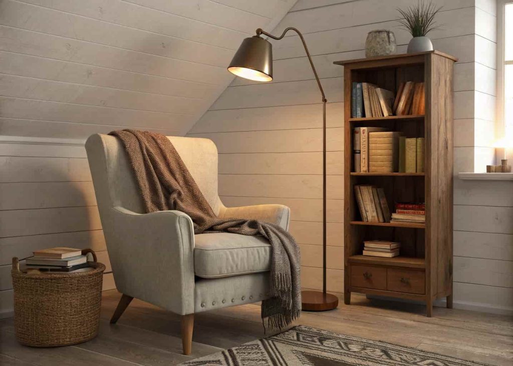 A corner with a comfy armchair, soft throw, small bookshelf, and a warm reading lamp.