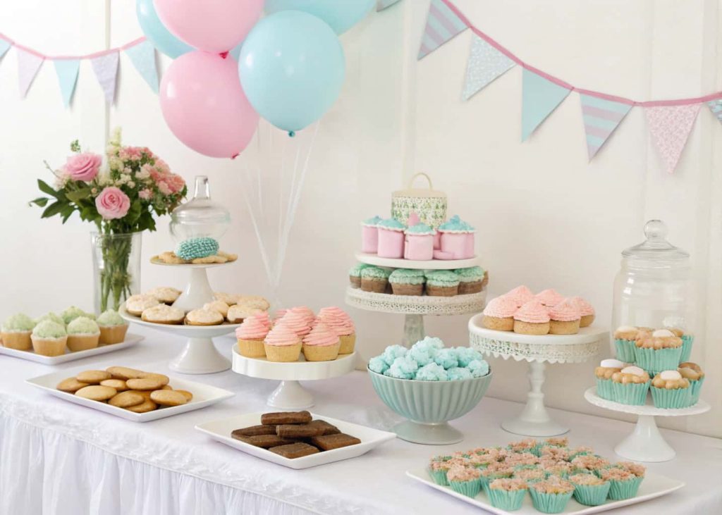 stylish baby shower dessert table with cupcakes, cookies, and pastel decorations