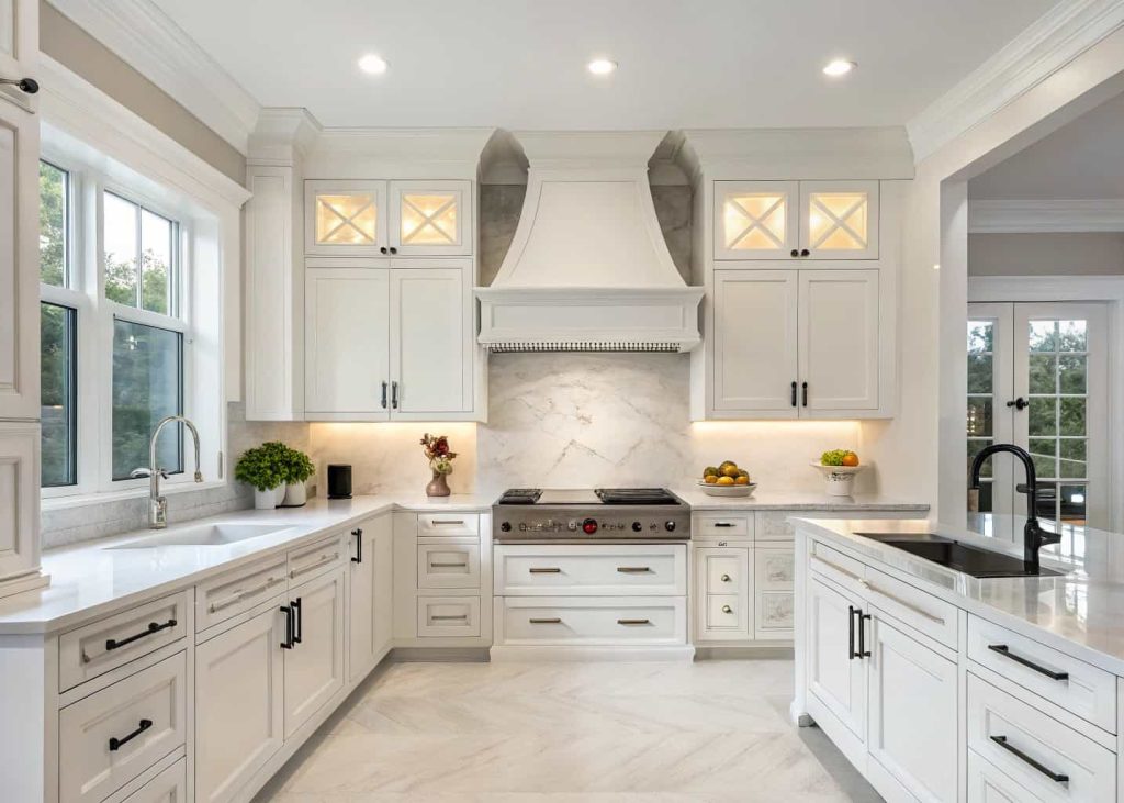 Modern kitchen with a cabinet-style custom range hood, white cabinetry, clean and sleek design.