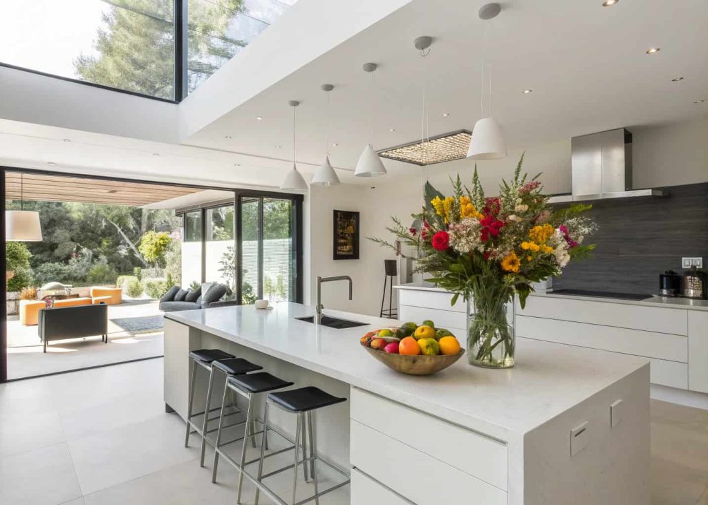 A modern kitchen island decorated with fresh flowers and a stylish fruit bowl, bright contemporary interior, minimalistic design”