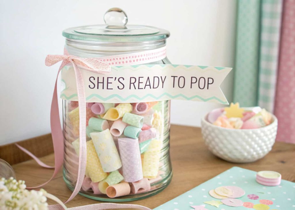 Baby shower memory jar with pastel decorations, ribbons, heartfelt notes from guests, ‘She’s Ready to Pop’ theme.”