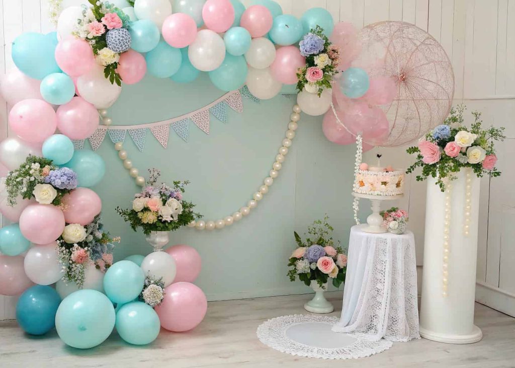 Baby shower balloon garlands and floral arrangements in pastel colors with decorative accents”