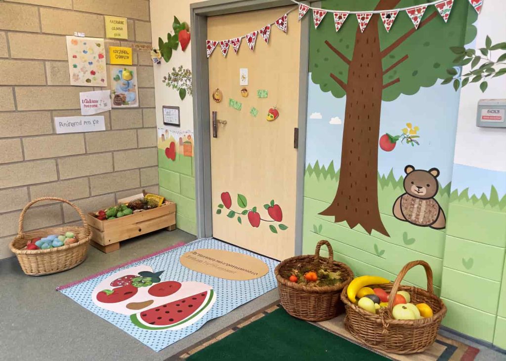Door showing a picnic scene with paper blankets, baskets, fruits, and cute animal cutouts.