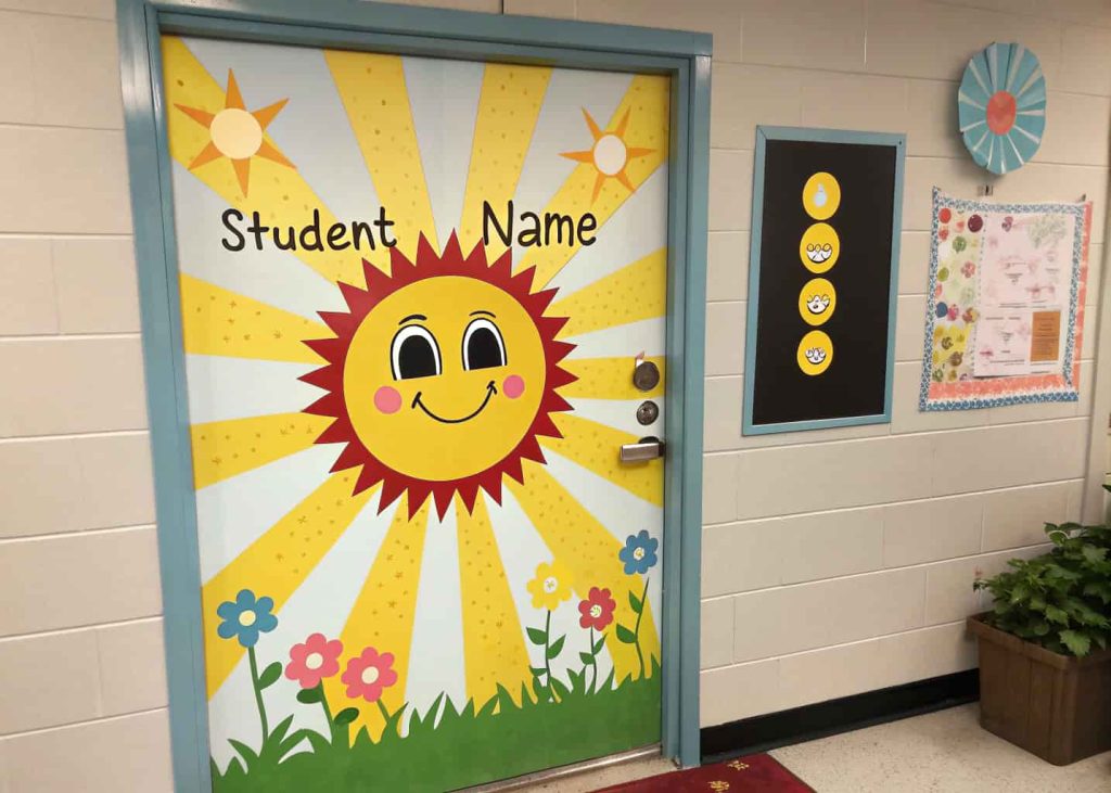 Door featuring a large smiling sun with yellow rays, each ray labeled with a student’s name, bright and cheerful spring theme.