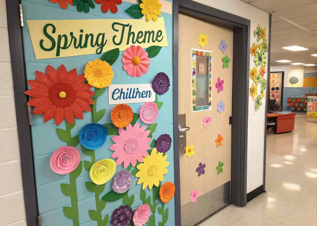 colorful classroom door covered with handmade paper flowers, bright spring theme, kids names on flowers, cheerful school environment