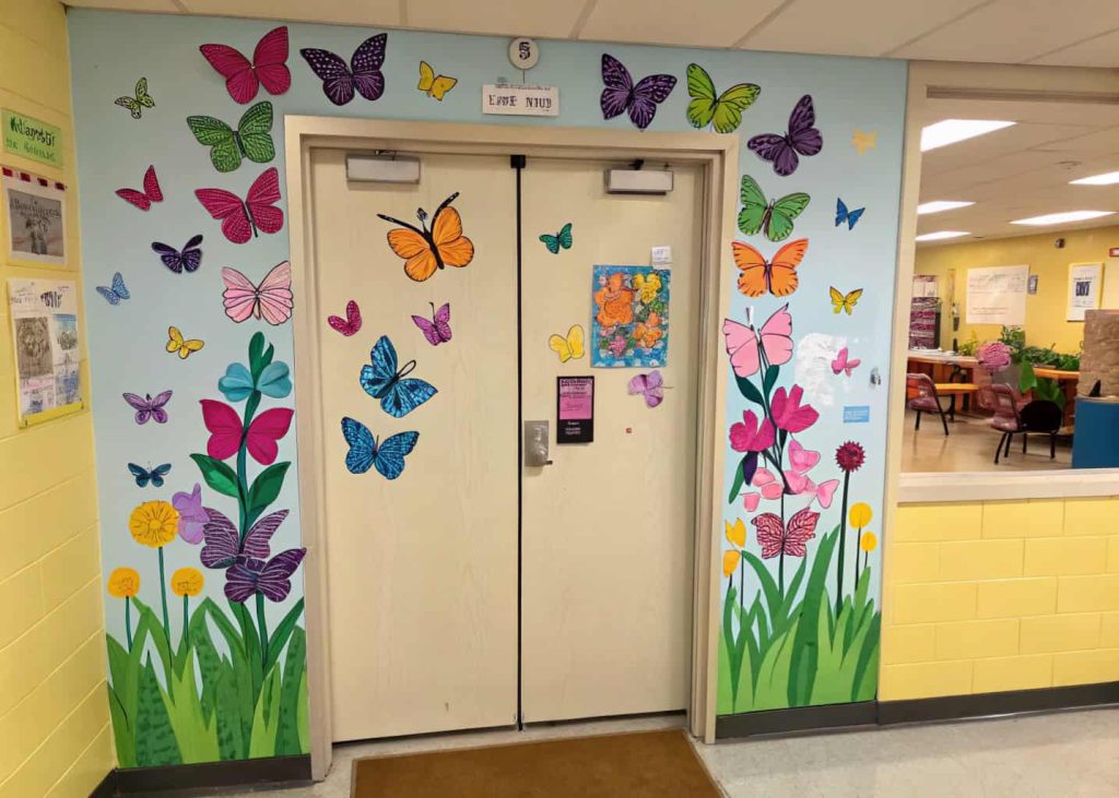 classroom door with many colorful butterflies, spring garden theme, bright and creative look