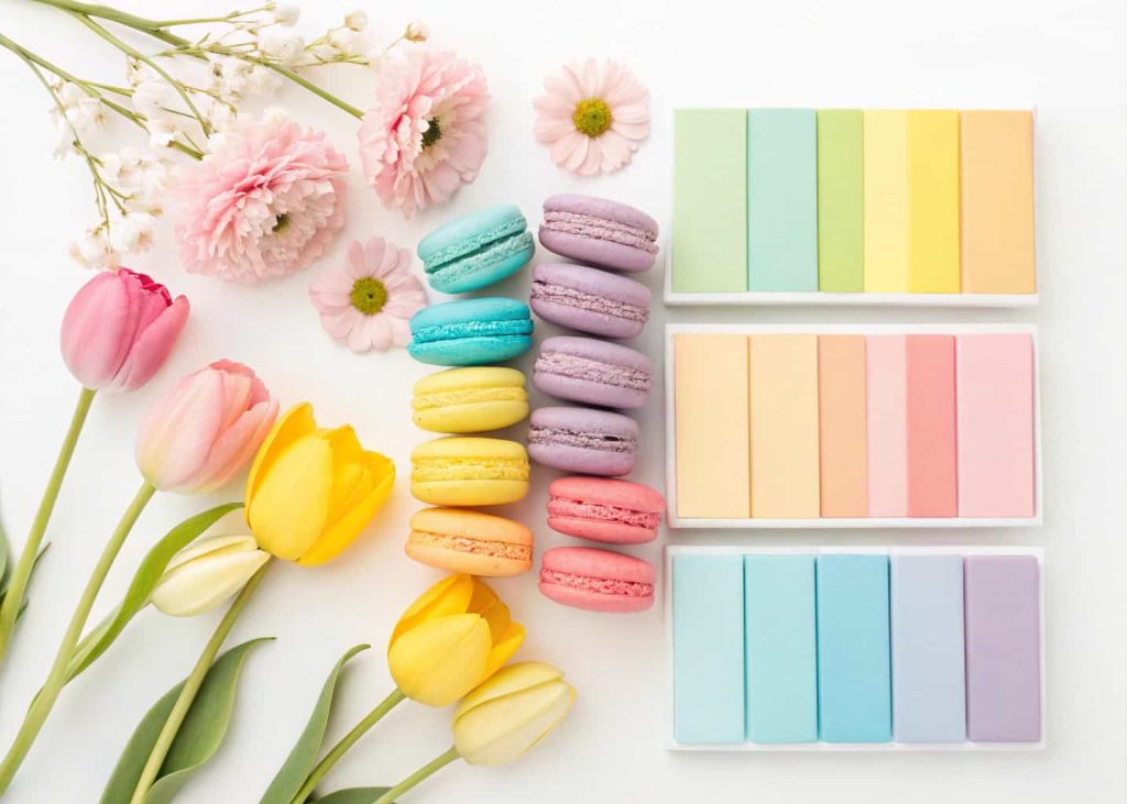 Full rainbow pastel spring color palette, cheerful flat lay with soft pink, yellow, blue, lavender, peach and mint color swatches arranged together, white background, bright spring festival aesthetic photography