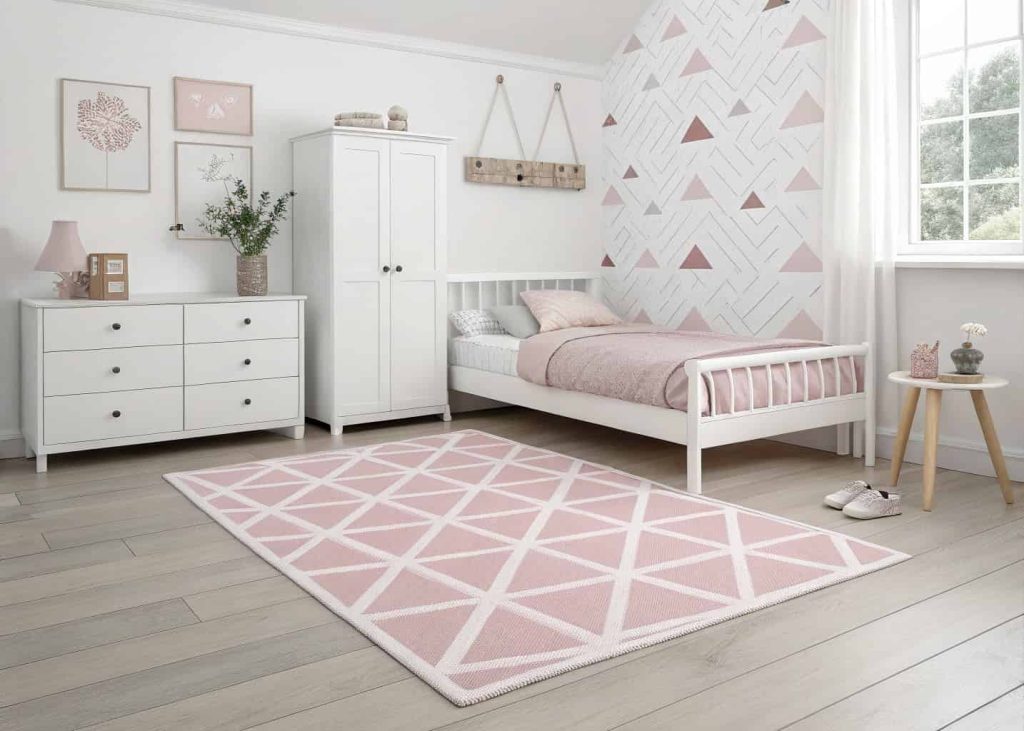 A minimalist Scandinavian-inspired bedroom with a pastel pink geometric rug, white bed frame, and clean simple decor.