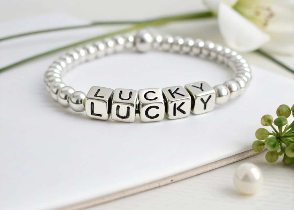 Minimalist letter bead bracelet spelling lucky with silver spacer beads on white background