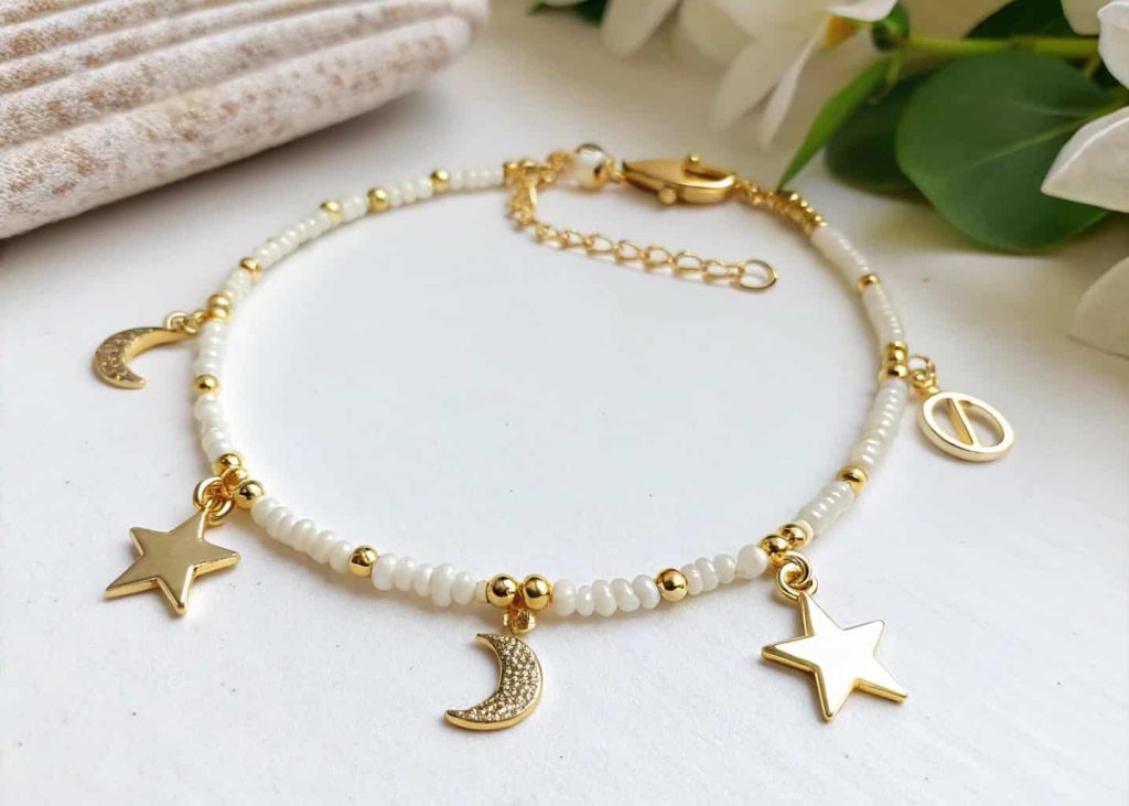 Mixed bead charm bracelet with gold star moon charms and seed beads in ivory tones