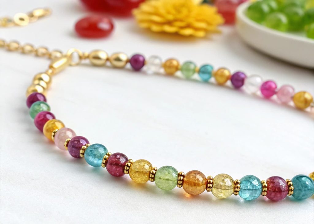 Macro shot of a beaded necklace showing small gold spacer beads alternating with colorful acrylic beads on a clean white background