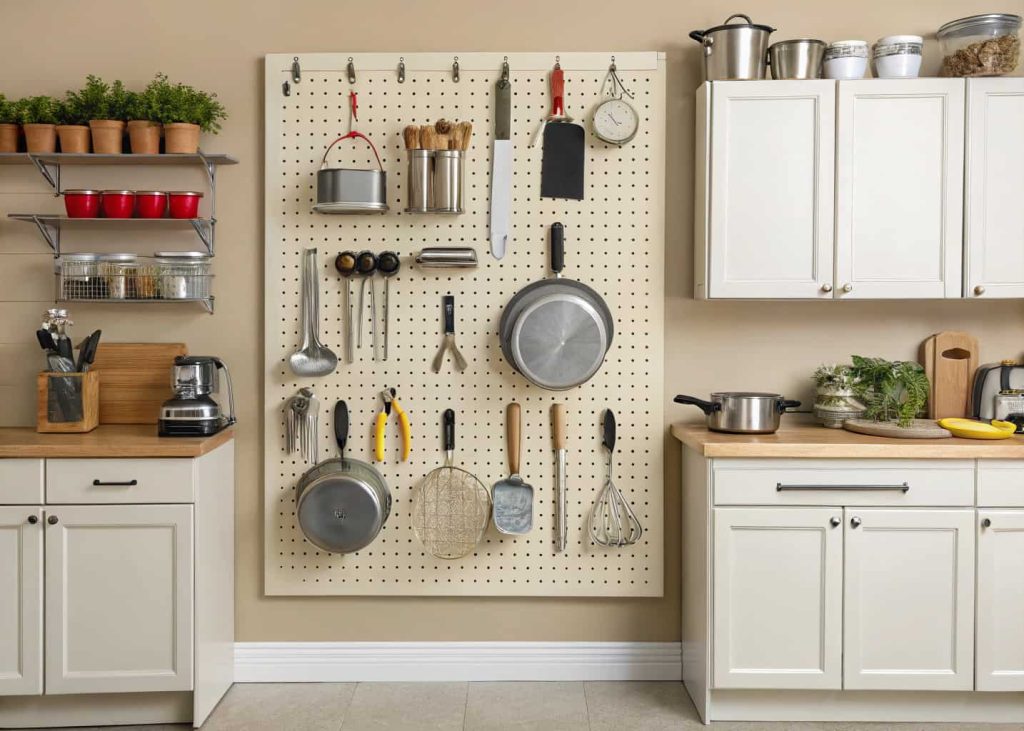 Kitchen wall with pegboard holding utensils and tools