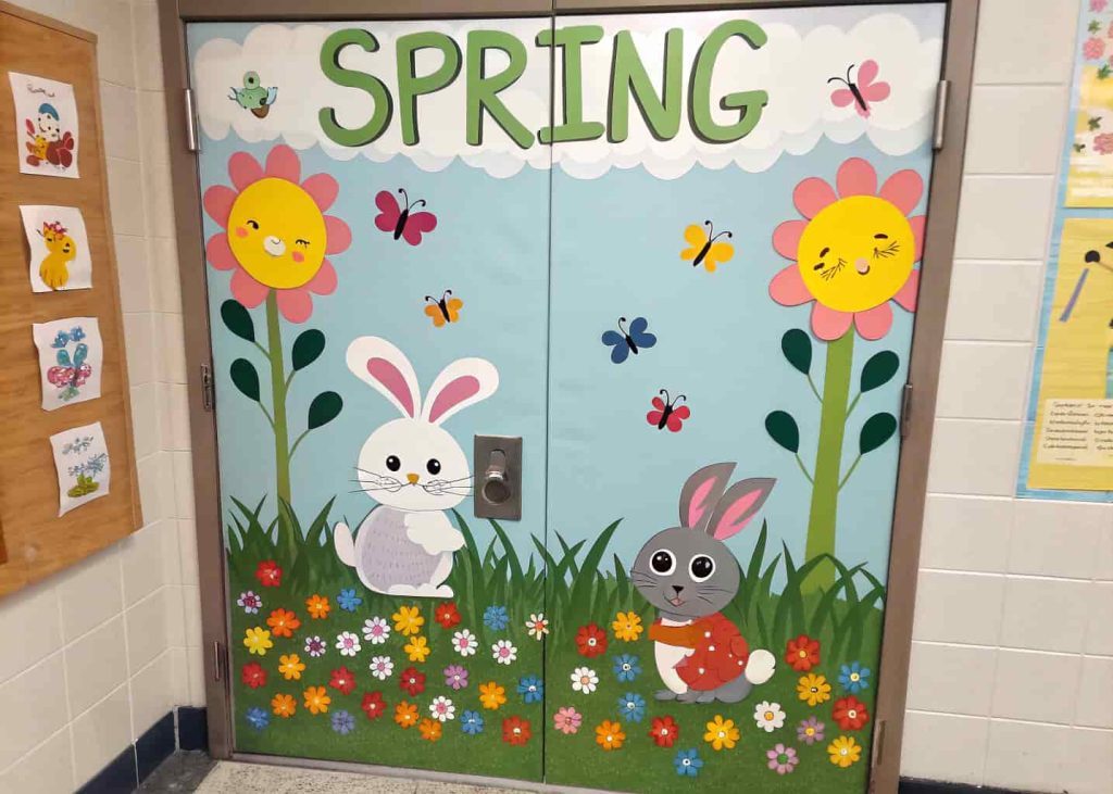 Door showing a spring scene with bunnies, chicks, and flowers, with student name tags on animals.