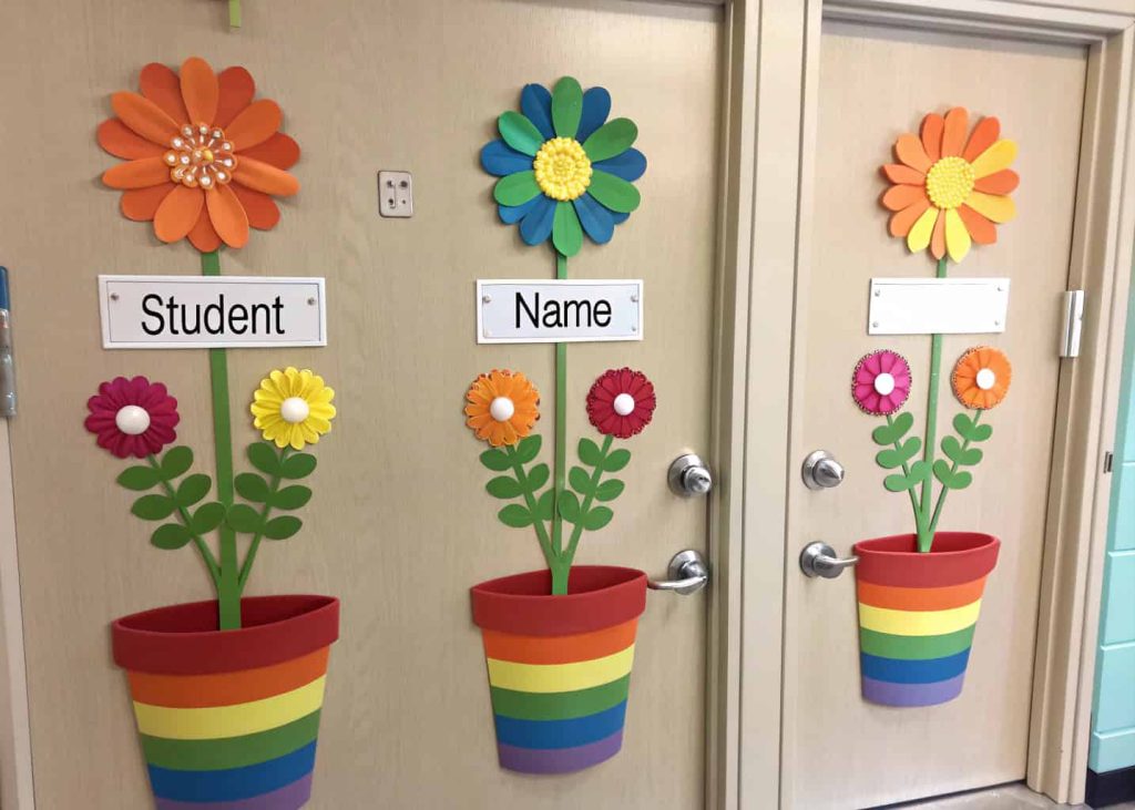 Door with rainbow-colored flower pots and paper flowers, each labeled with a student’s name.