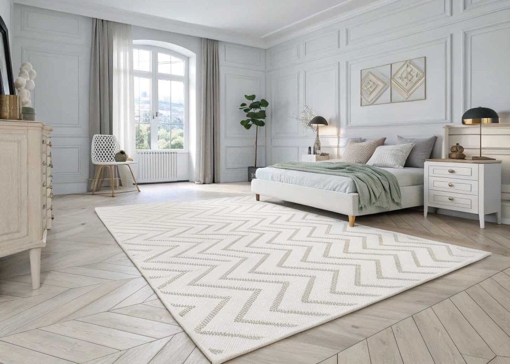 A white chevron geometric rug in a bright modern bedroom with a clean contemporary design