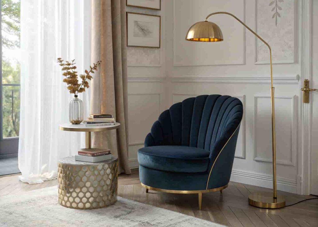 A deep navy velvet fan-back chair in a Neo Deco reading nook with a brass floor lamp and marble side table