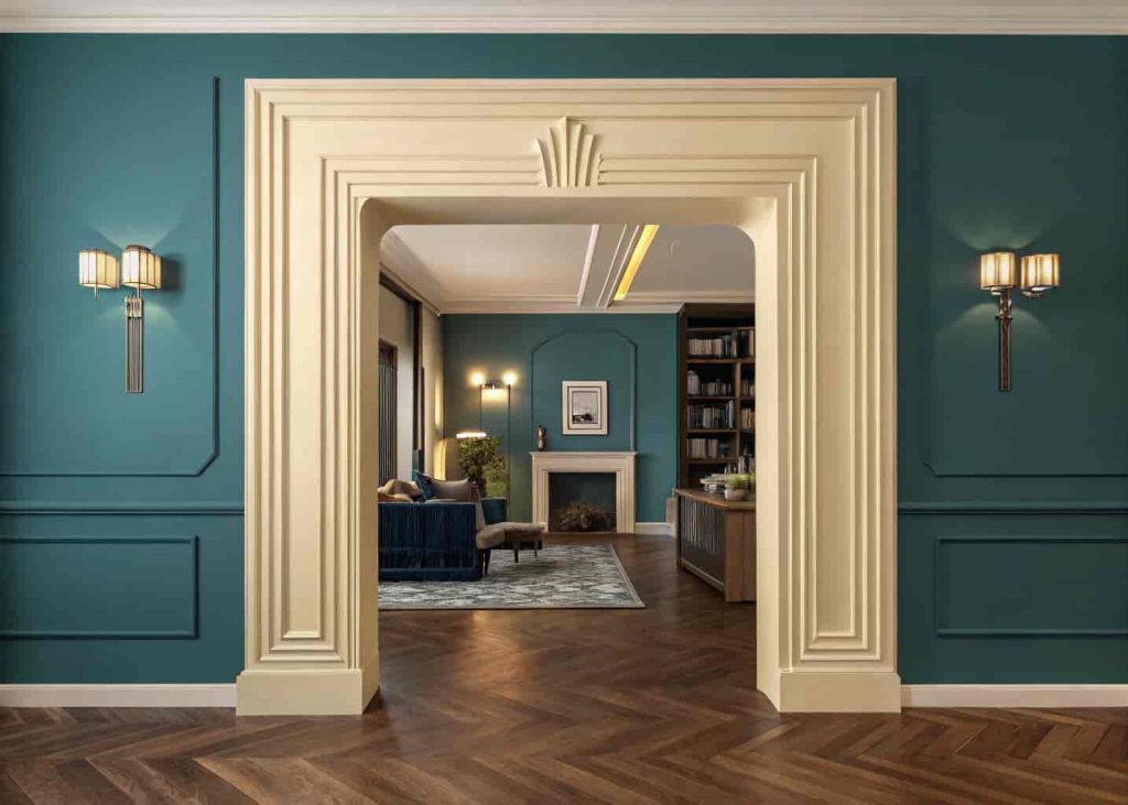 A stepped Art Deco cream archway set against a deep teal wall leading into a Neo Deco interior space