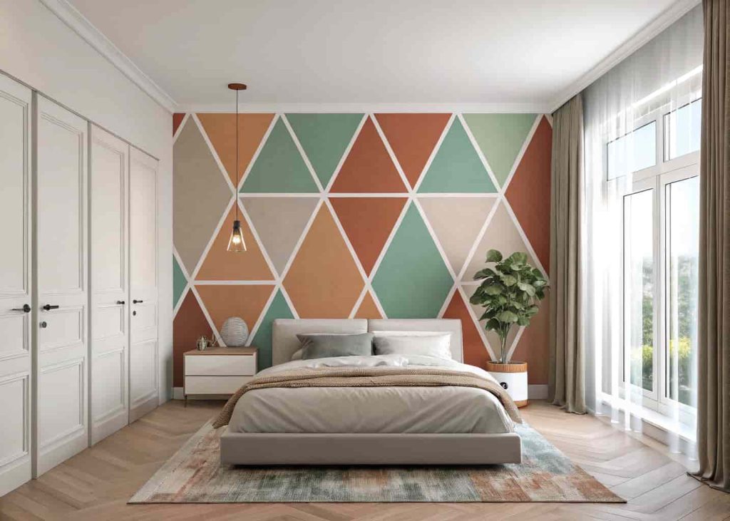 A modern bedroom with a geometric triangle accent wall painted in terracotta, sage green, and warm white, with minimalist furniture and neutral linen bedding.