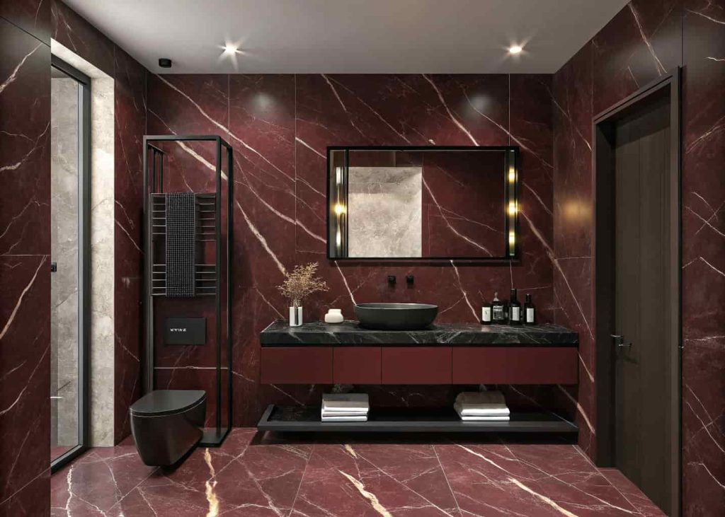 Dark red marble bathroom with matte black fixtures and dramatic moody lighting for a luxury feel.