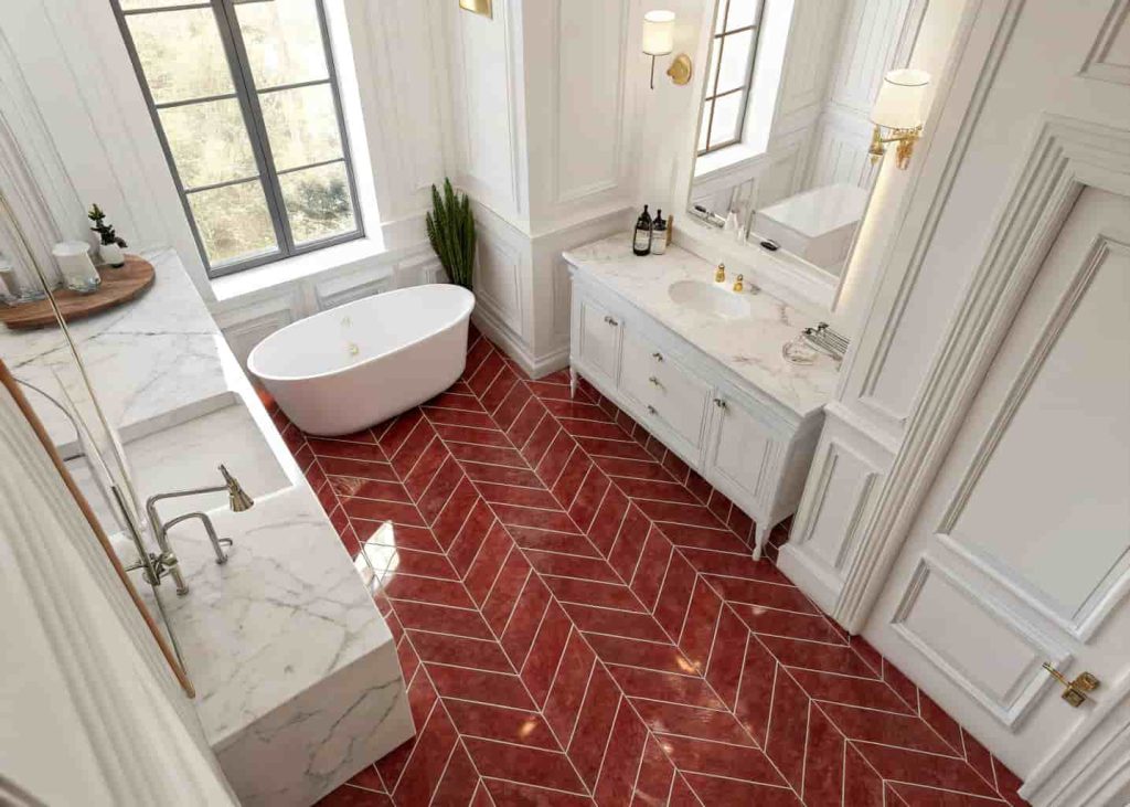 Red marble herringbone floor pattern in a bright white bathroom creating stunning visual movement.