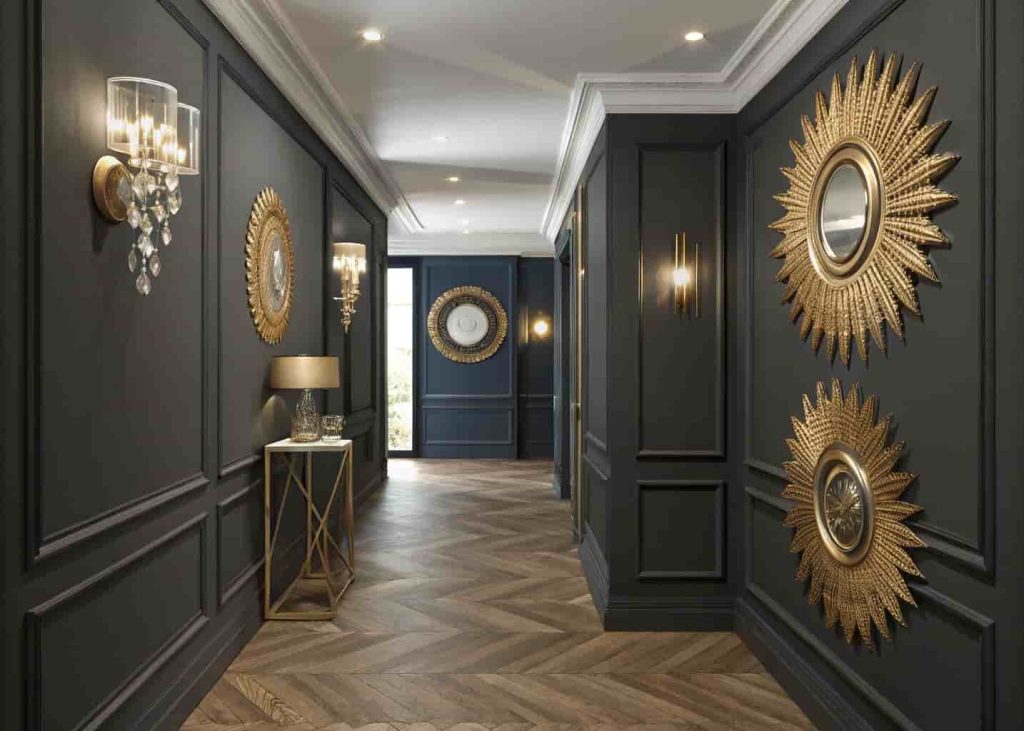 A hallway gallery wall with three gold sunburst mirrors of different sizes arranged on a dark charcoal background