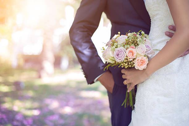 A soft-toned bridal bouquet with blush spray roses, dusty mauve astilbe and pale pink lisianthus, romantic dreamy bridal portrait, soft diffused pastel light, watercolour aesthetic photography