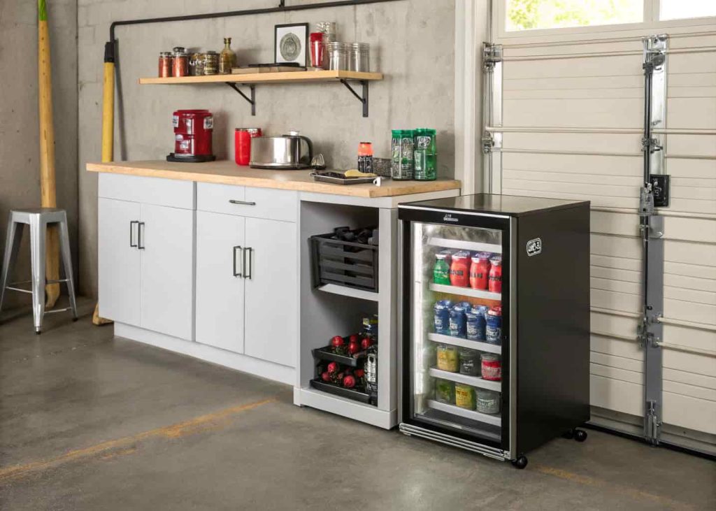 Compact mini fridge placed beside a garage workbench stocked with cold drinks