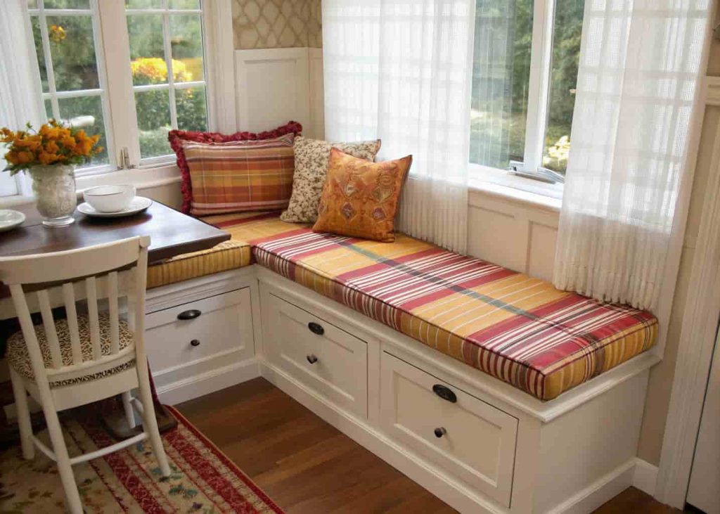 Plaid and striped cushions on small breakfast nook bench
