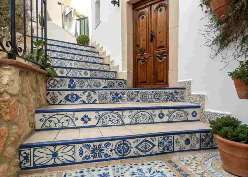 Hand-painted decorative tiles on stair risers at a Mediterranean villa exterior entrance