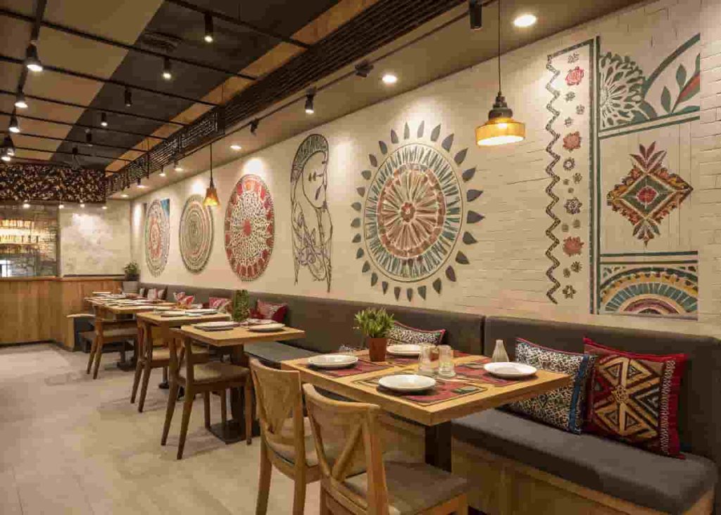 Modern restaurant interior with locally inspired design featuring hand-painted ceramics, traditional textiles, and handcrafted wooden furniture that reflects the restaurant's cultural roots.