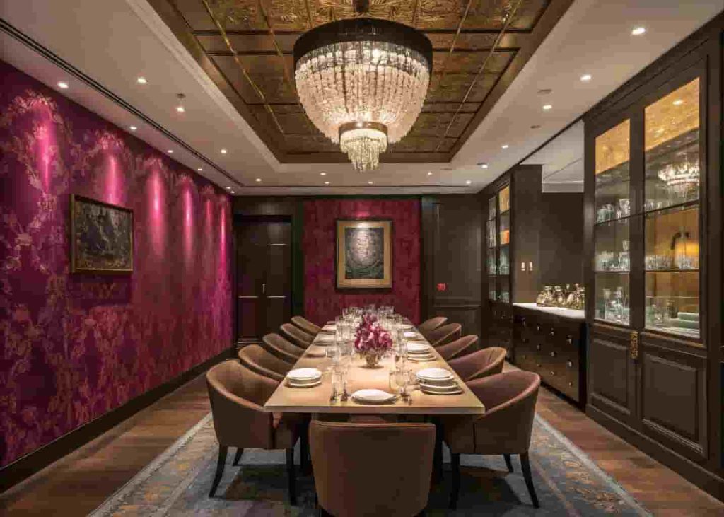 Luxurious modern private dining room with jewel-toned wallpaper, custom long dining table, crystal glassware, dramatic chandelier, and moody intimate lighting for an exclusive dining experience