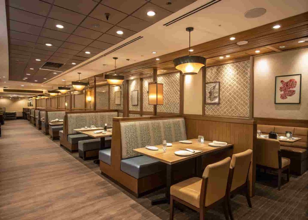 Restaurant dining room with smart table spacing, low partitions, and banquette seating for privacy