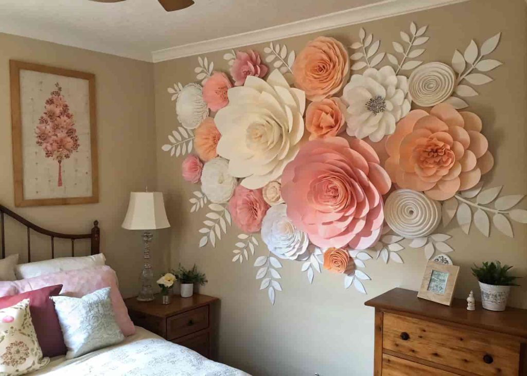 DIY paper flower wall art in pink and white tones decorating a cozy bedroom wall.