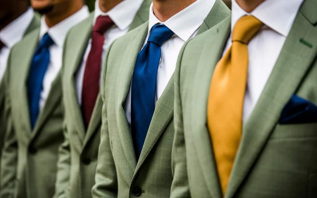 Sage green groomsmen attire paired with mixed tie colors