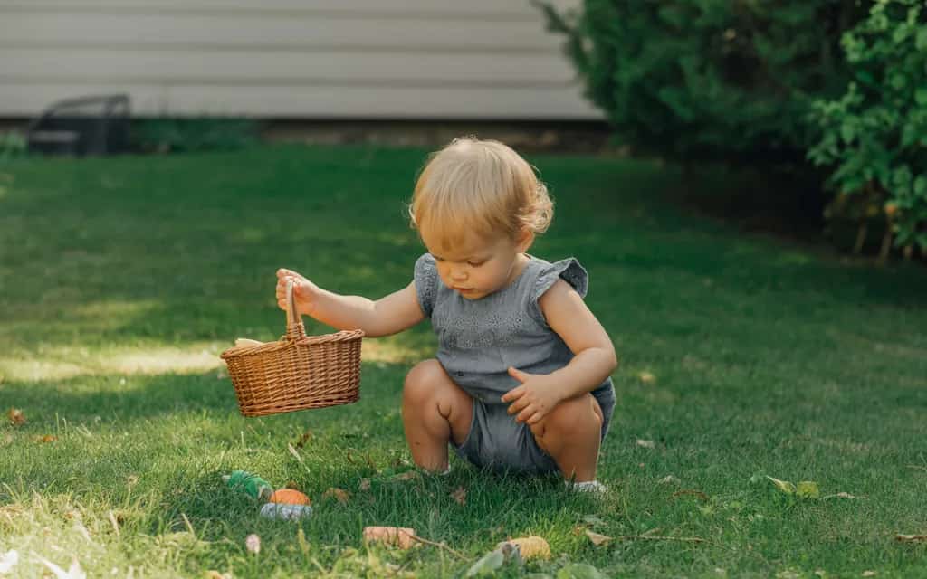Toddler on a backyard treasure hunt looking for hidden household items
