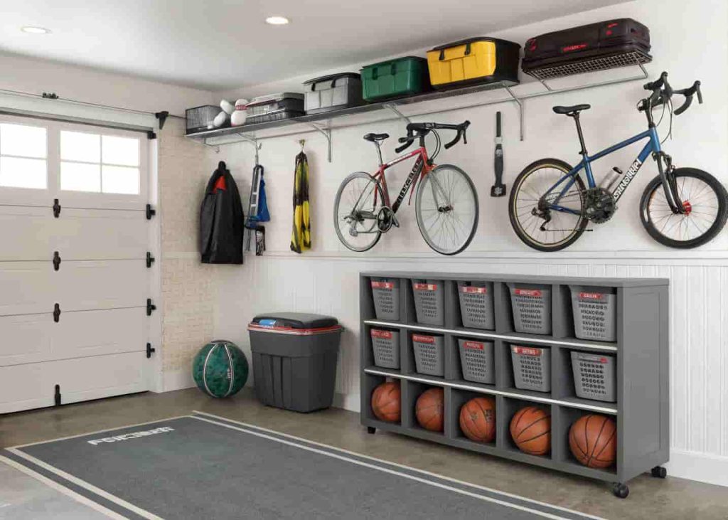 Garage sports equipment station with wall-mounted bike hooks, ball bin, and organized helmet and gear storage