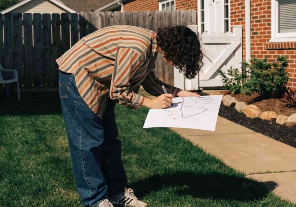 Homeowner planning yard layout with a notebook in the backyard