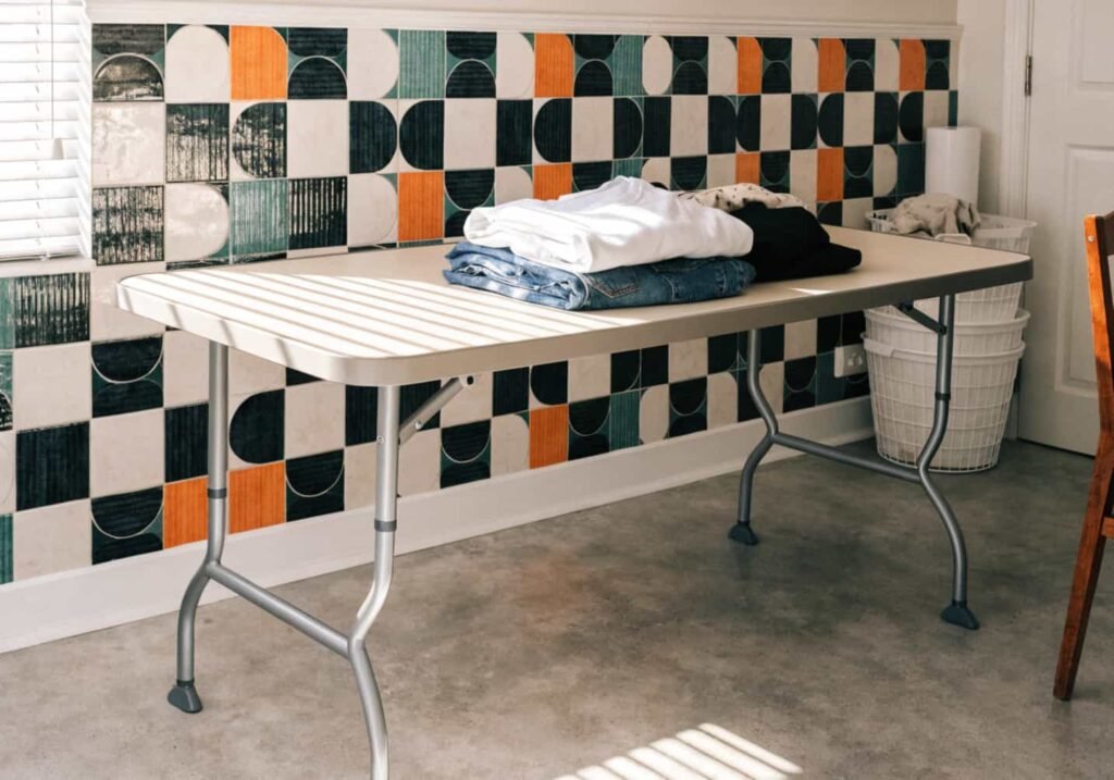 Geometric tile backdrop behind modern laundry folding table