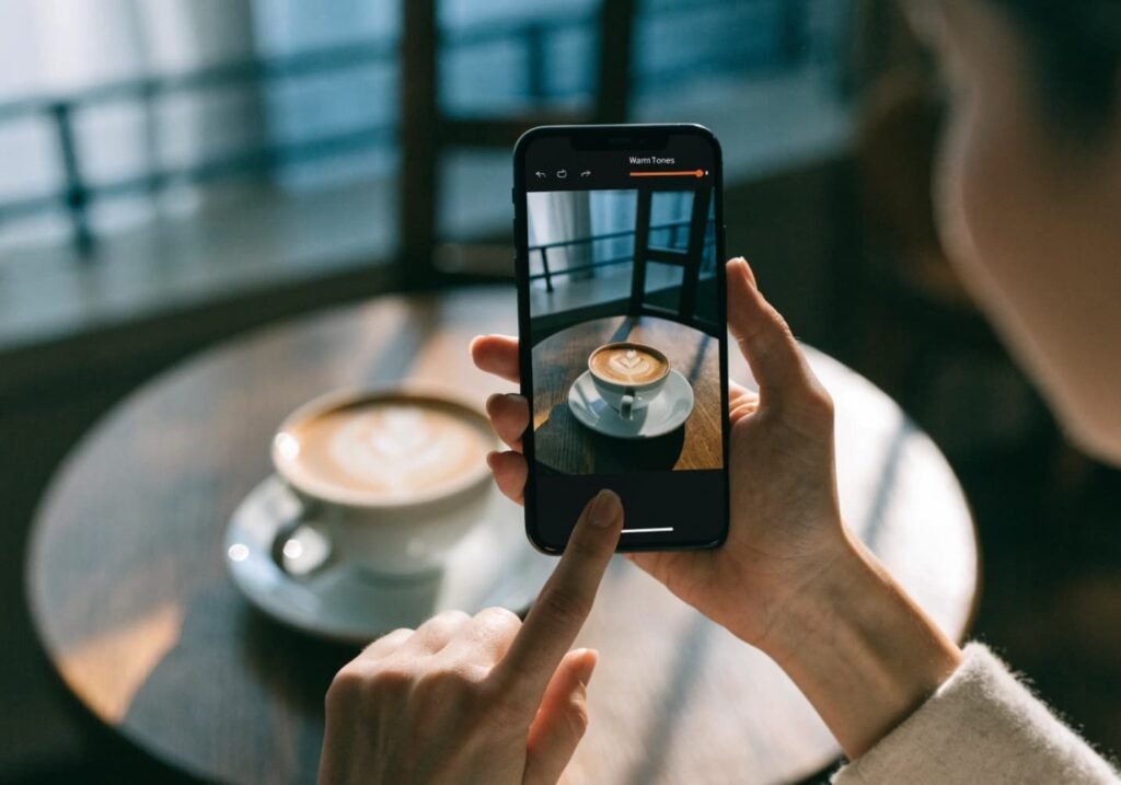 Phone screen showing light warm-toned editing of a coffee shop photo