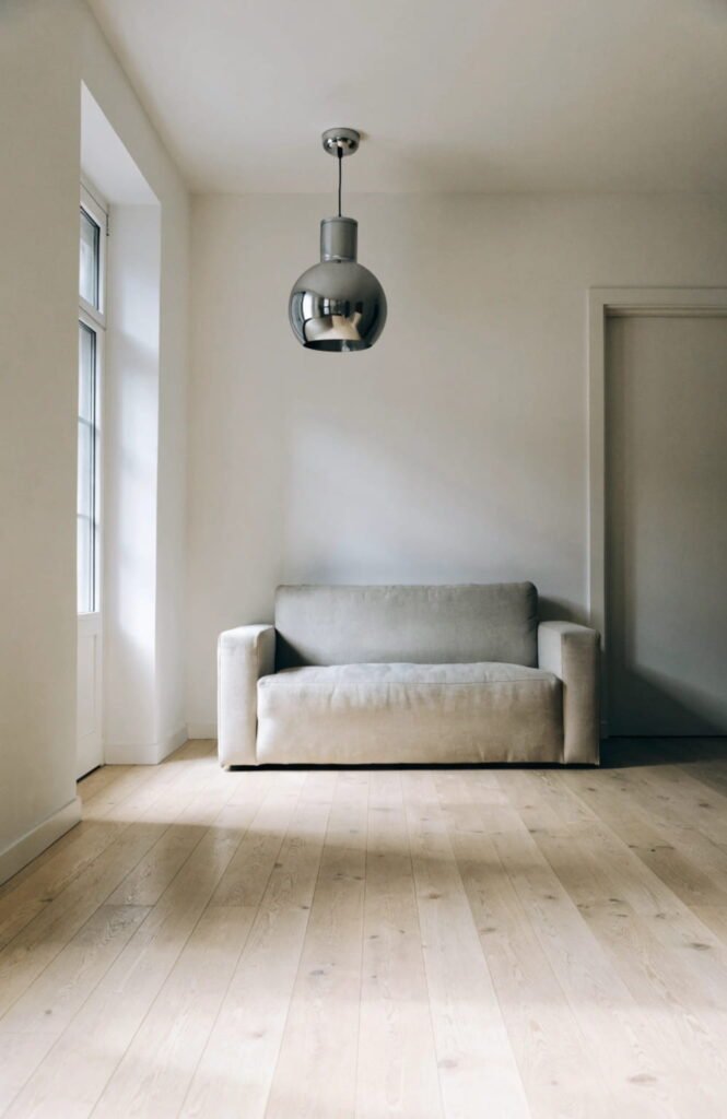 Single chrome pendant light in a calm, minimalist living room