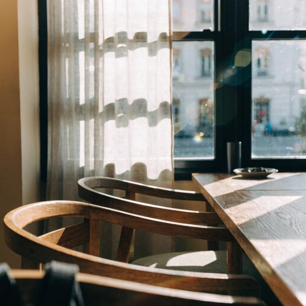 natural sunlight through cafe window with sheer curtains