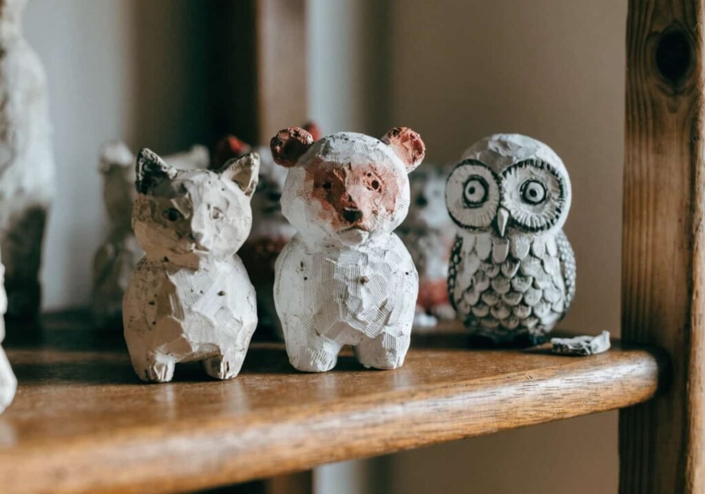 mini clay animal figures on wooden shelf