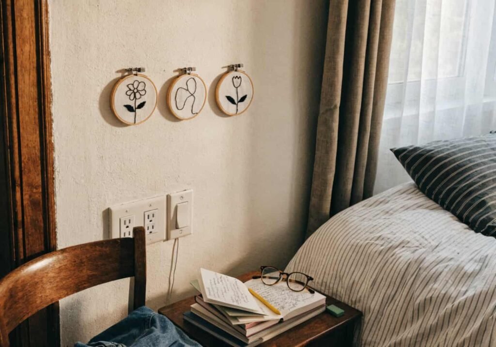 Bedroom wall decorated with three small minimalist floral embroidery hoops