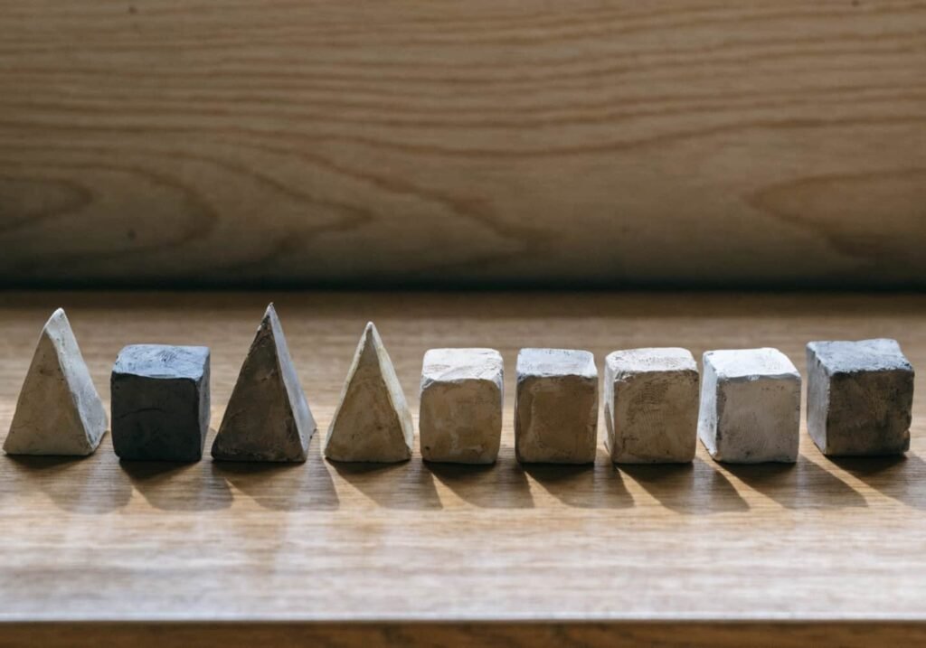 Handmade clay geometric shapes in earthy tones arranged in a row